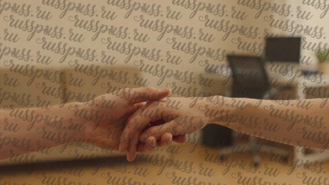 Руки двух людей держатся за руки в молчании — без слов, только забота.